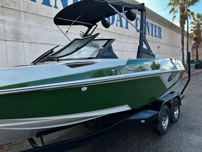Slide: The Image of 2021 Axis T22 boat in green and white, parked outside a boat center. - 3