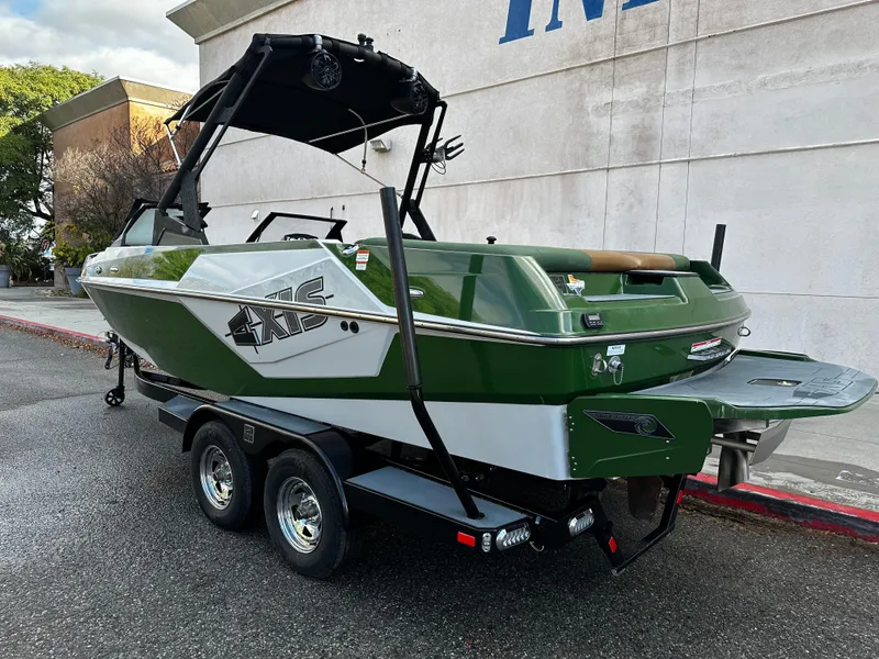 Slide: The Image of 2021 Axis T22 boat on a trailer, green and white exterior, parked outdoors. - 4