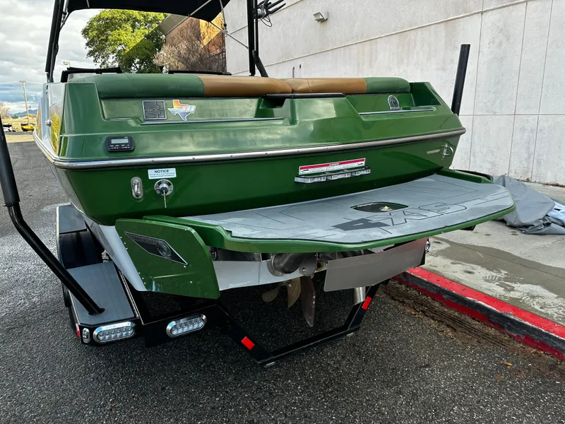 Slide: The Image of 2021 Axis T22 green boat rear view with swim platform and trailer. - 5