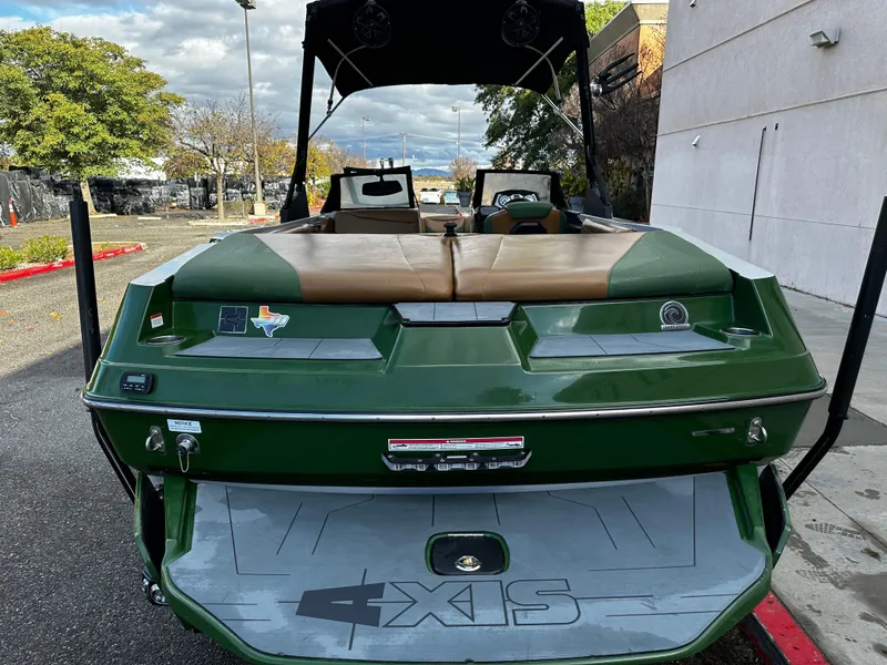Slide: The Image of 2021 Axis T22 green boat rear view with tan seats and swim platform. - 7