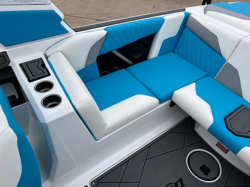 Slide: The Image of 2024 Tigé Z3 boat interior with blue and white seating, cup holders, and modern design. - 11