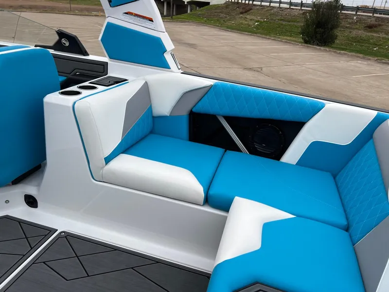 Slide: The Image of 2024 Tigé Z3 boat interior with blue and white seating, cup holders, and modern design. - 12
