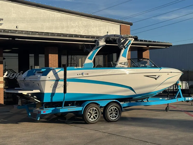 Slide: The Image of 2024 Tigé Z3 boat on trailer, blue and white design, parked outside a building. - 3