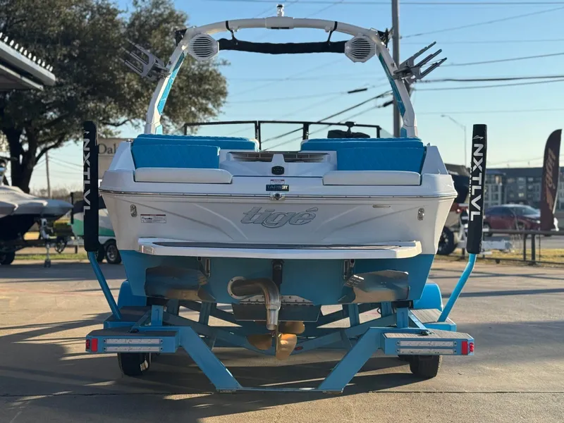 Slide: The Image of 2024 Tigé Z3 boat on trailer, rear view, blue and white design, outdoor setting. - 4