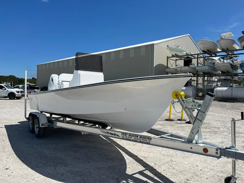 The Image of 2026 C-Hawk 23 Center Console boat on trailer at marina under clear blue sky. - 1