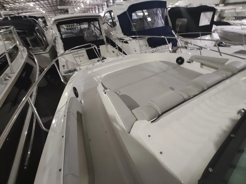 Slide: The Image of 2023 Sea Ray 320 Sundancer yacht in a marina, surrounded by other boats. - 26