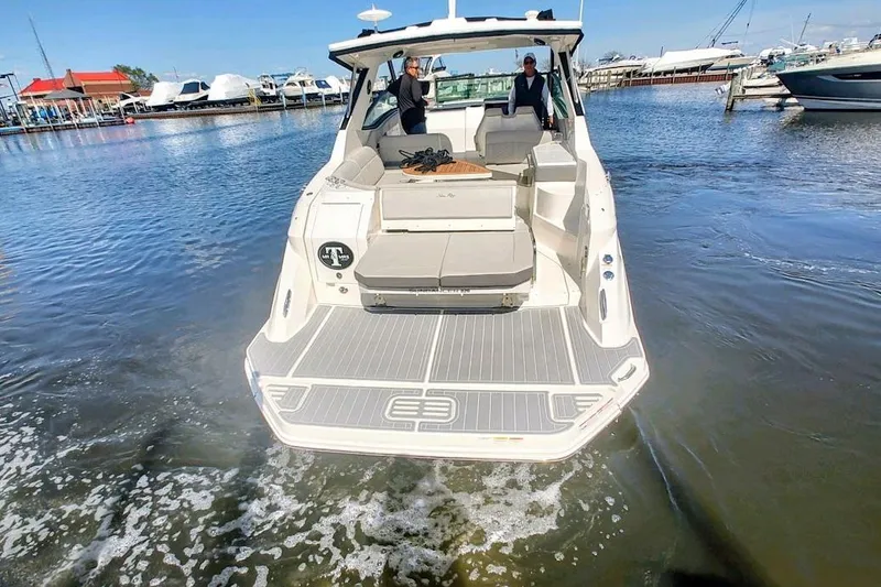 Slide: The Image of 2023 Sea Ray 320 Sundancer boat docked at marina, rear view. - 3
