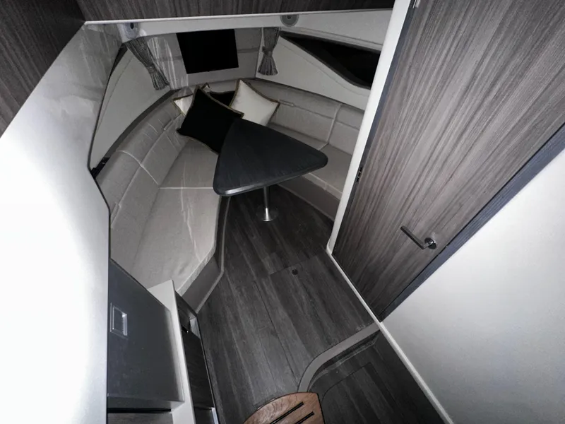 Slide: The Image of 2023 Sea Ray 320 Sundancer cabin interior with modern furnishings and wood finishes. - 34