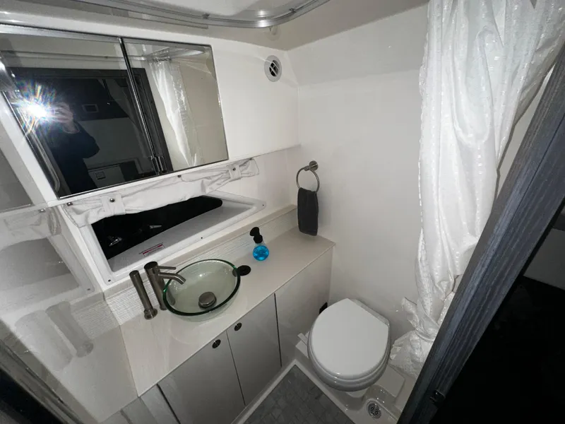 Slide: The Image of Modern bathroom in 2023 Sea Ray 320 Sundancer yacht with glass sink and toilet. - 35