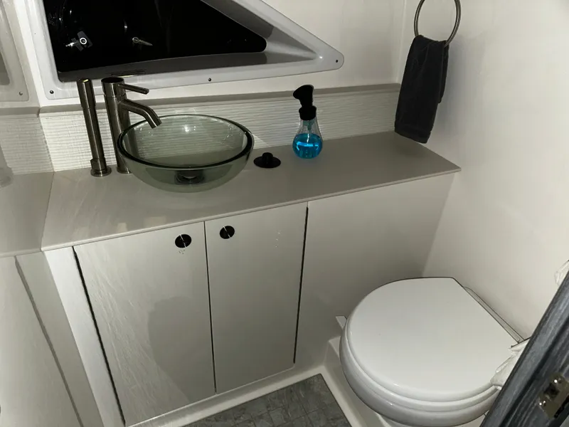 Slide: The Image of Modern bathroom in 2023 Sea Ray 320 Sundancer yacht with glass sink and toilet. - 36