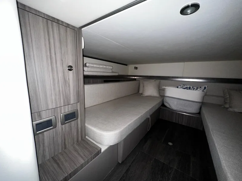Slide: The Image of Interior cabin of 2023 Sea Ray 320 Sundancer with modern wood finish and seating. - 41