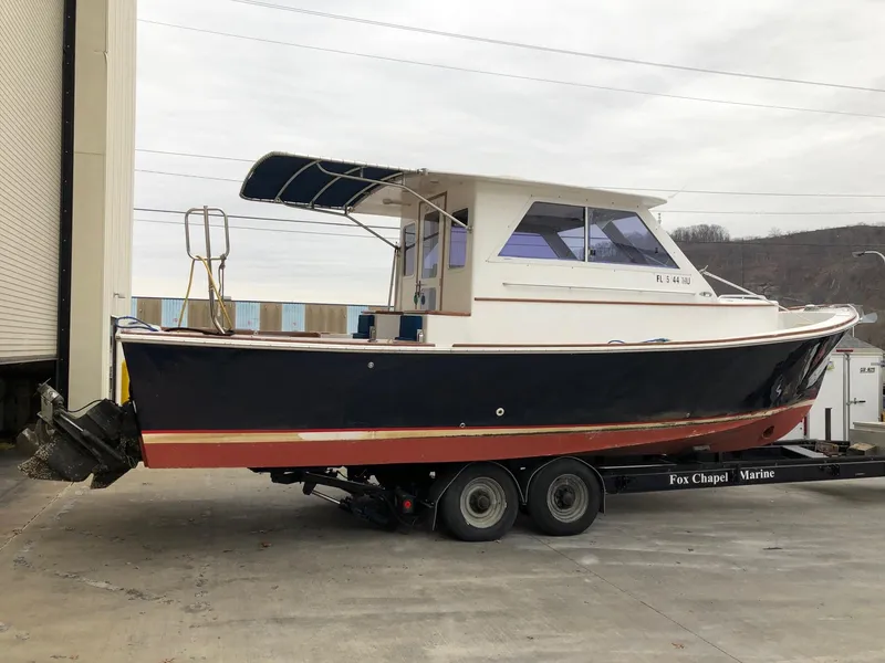 Slide: The Image of 2005 Morgan 31 boat on a trailer at a marina. - 2