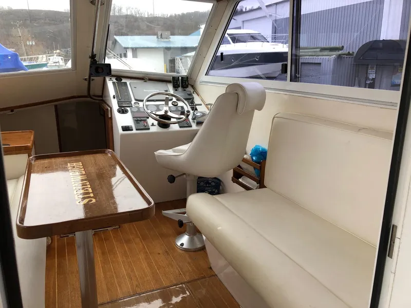Slide: The Image of Interior of a 2005 Morgan 31 boat with helm, seating, and wooden table. - 9