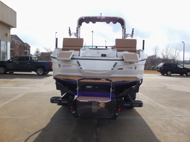 Slide: The Image of 2024 MasterCraft X24 boat rear view in a parking lot. - 4