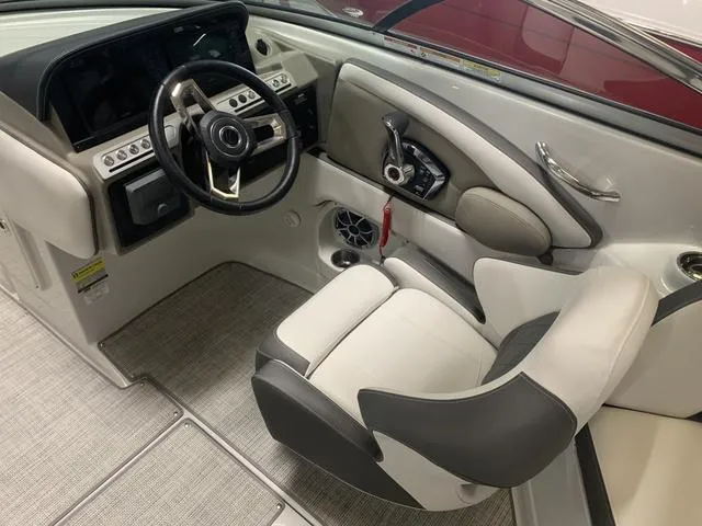 Slide: The Image of 2024 Crownline E255 boat cockpit with steering wheel and captain's chair. - 11