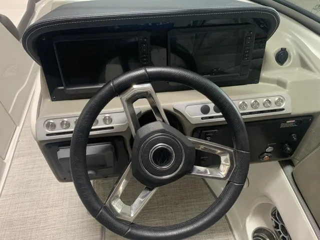 Slide: The Image of 2024 Crownline E255 boat dashboard with modern steering wheel and dual display screens. - 12