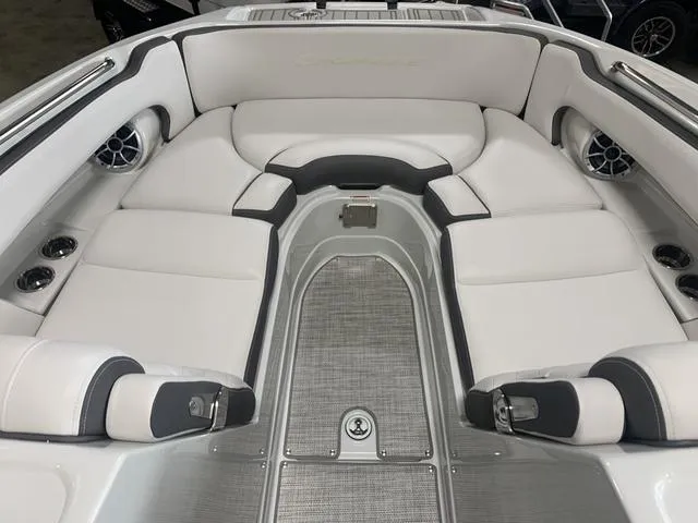 Slide: The Image of 2024 Crownline E255 boat interior with white cushioned seating and built-in speakers. - 13