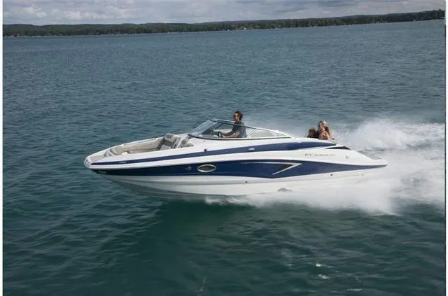 Slide: The Image of 2024 Crownline E255 boat cruising on a lake. - 23
