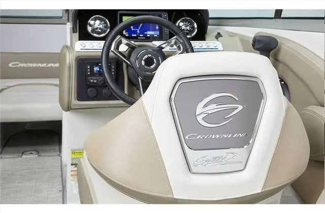 Slide: The Image of 2024 Crownline E255 boat interior, featuring steering wheel and dashboard. - 30