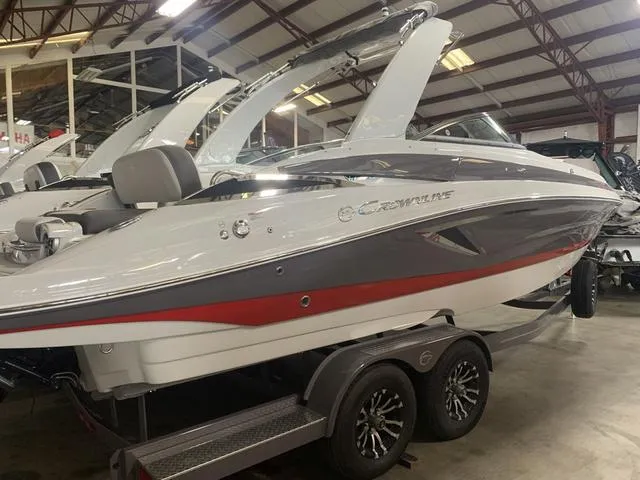 Slide: The Image of 2024 Crownline E255 boat on a trailer in a showroom. - 4