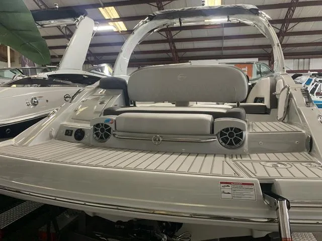 Slide: The Image of 2024 Crownline E255 boat interior with seating and speakers in a showroom. - 5