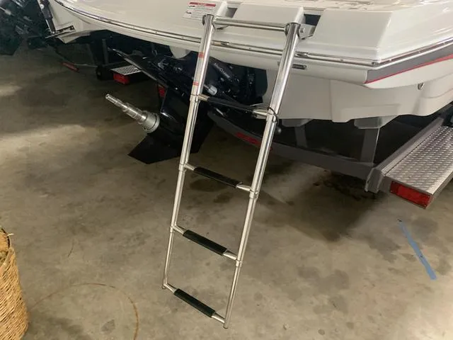 Slide: The Image of 2024 Crownline E255 boat with extended ladder in a garage. - 7