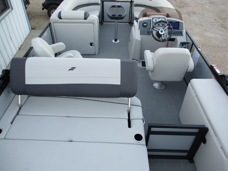 Slide: The Image of 2024 Starcraft EXS 1 Q DH pontoon boat interior with helm, seating, and table. - 13