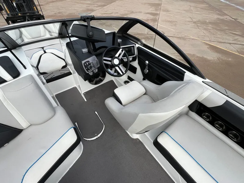 Slide: The Image of Interior of a 2018 Malibu 21 VLX boat with modern seating and steering wheel. - 11