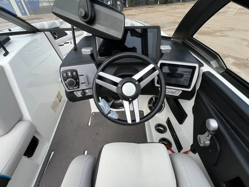 Slide: The Image of 2018 Malibu 21 VLX boat cockpit with steering wheel and digital displays. - 12