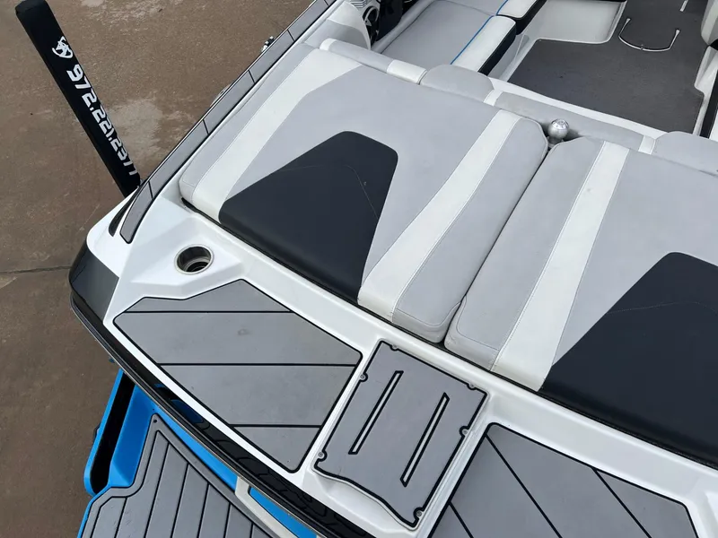 Slide: The Image of 2018 Malibu 21 VLX boat interior with cushioned seating and sleek design. - 5