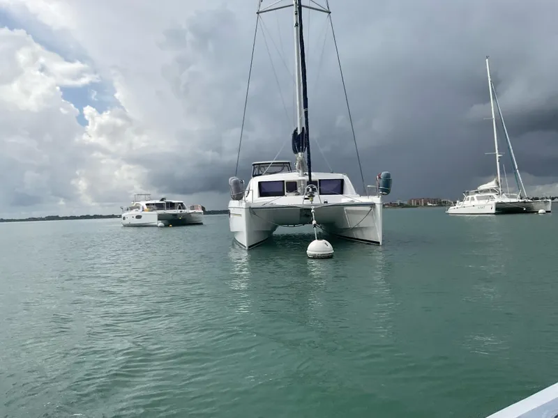 The Image of 2013 Leopard 39 Owner's Version catamaran anchored in calm waters under cloudy skies. - 0