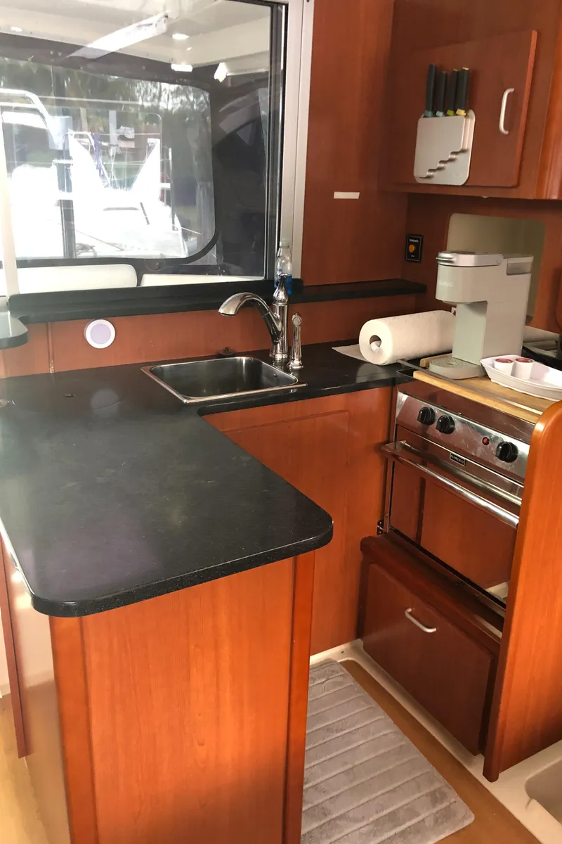 Slide: The Image of 2013 Leopard 39 Owner's Version yacht kitchen with wood cabinetry and modern appliances. - 20