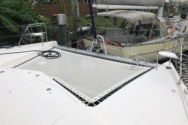 Slide: The Image of 2013 Leopard 39 Owner's Version catamaran with netting on deck, docked near other boats. - 7