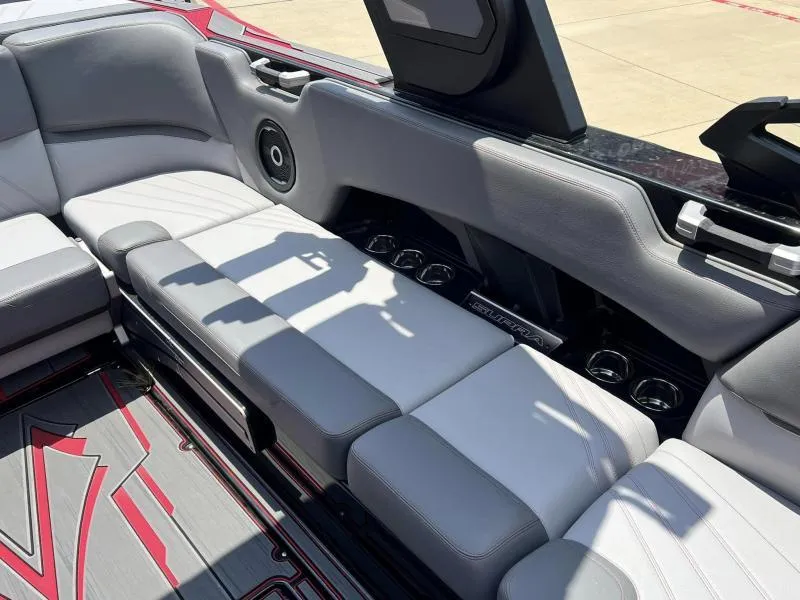 Slide: The Image of 2024 Supra SA 400 boat interior with gray and white seating, cup holders, and speaker. - 11