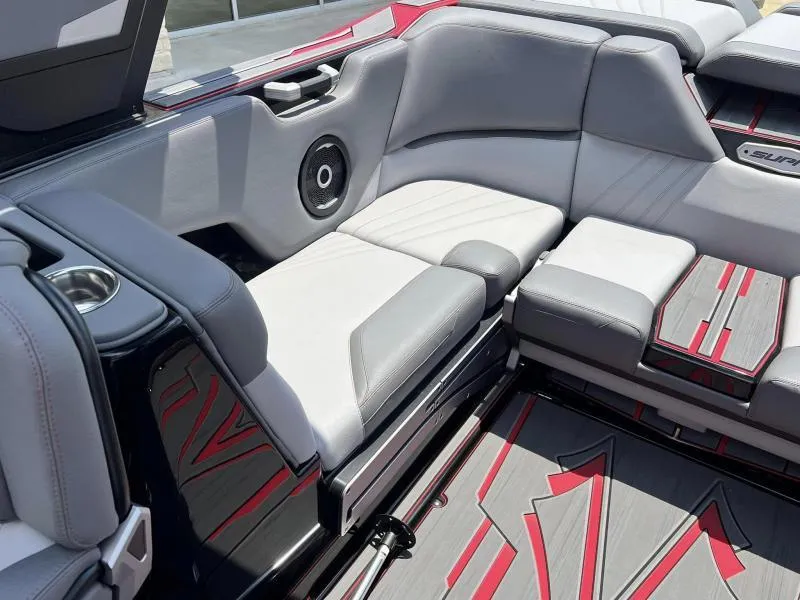Slide: The Image of 2024 Supra SA 400 boat interior with gray and red seating and speaker system. - 12