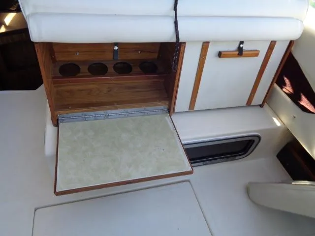 Slide: The Image of 1986 Sea Ray 250 Sundancer interior with fold-out table and storage compartments. - 14
