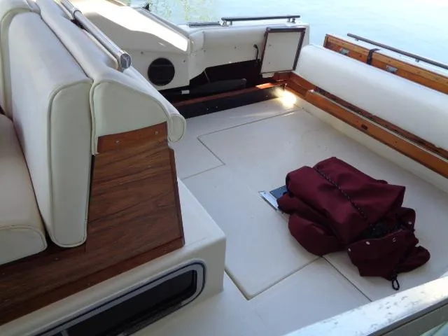 Slide: The Image of Interior of 1986 Sea Ray 250 Sundancer boat with white seating and wooden accents. - 20