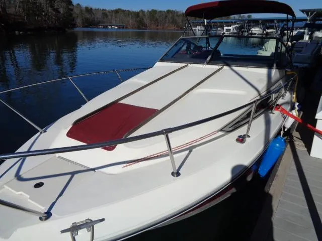 Slide: The Image of 1986 Sea Ray 250 Sundancer docked at a serene lake. - 21