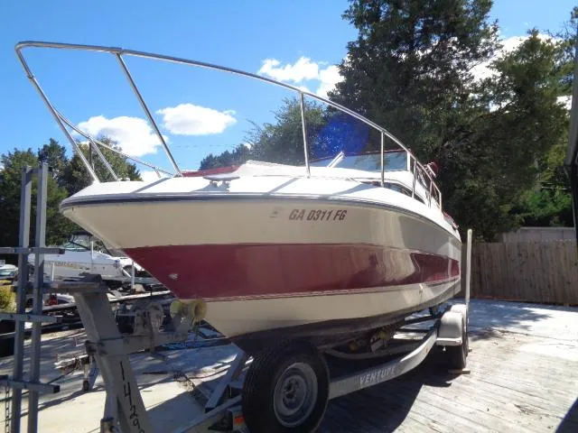 Slide: The Image of 1986 Sea Ray 250 Sundancer boat on a trailer in a sunny outdoor setting. - 22