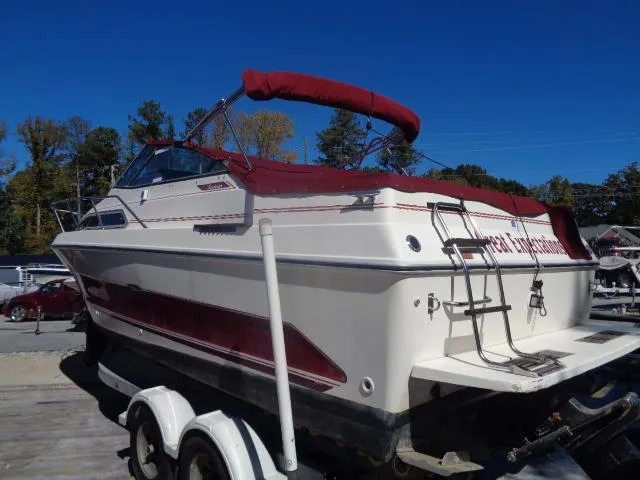 Slide: The Image of 1986 Sea Ray 250 Sundancer boat with red accents on a trailer. - 25