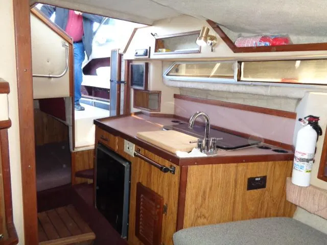Slide: The Image of Interior of 1986 Sea Ray 250 Sundancer boat with kitchenette and seating area. - 6