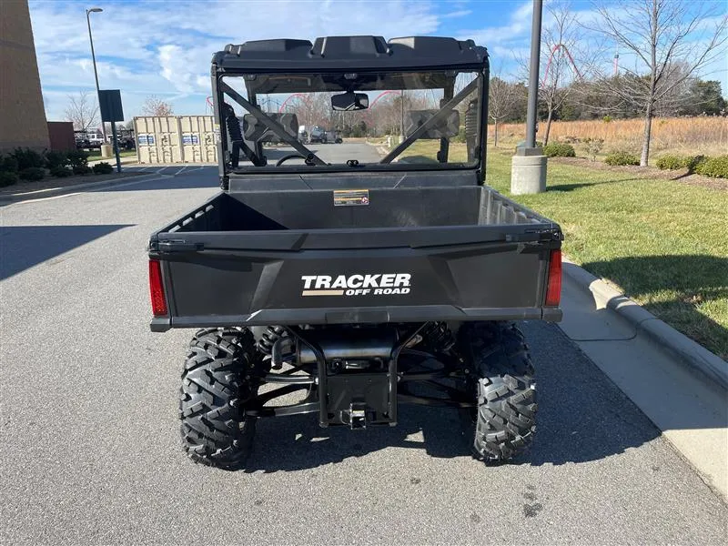 Slide: The Image of 2024 Tracker Off Road 800SX LE Camo utility vehicle, rear view, parked outdoors. - 2