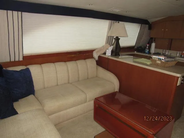 Slide: The Image of Interior of 2001 Ocean Yachts Super Sport with beige sofa and wooden cabinetry. - 3