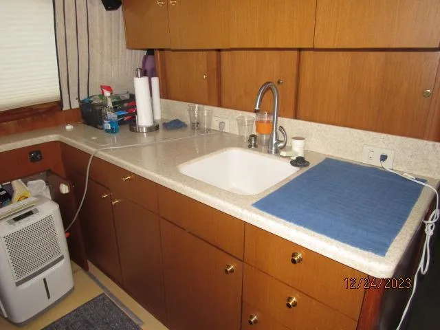 Slide: The Image of 2001 Ocean Yachts Super Sport kitchen with wooden cabinets and sink. - 6