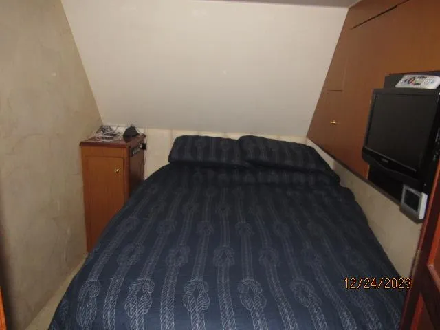 Slide: The Image of 2001 Ocean Yachts Super Sport cabin with bed, TV, and storage cabinet. - 10