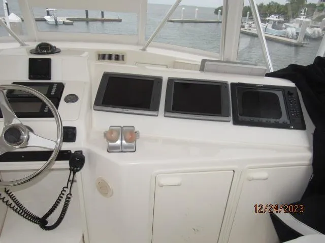 Slide: The Image of 2001 Ocean Yachts Super Sport helm with navigation screens and steering wheel. - 20
