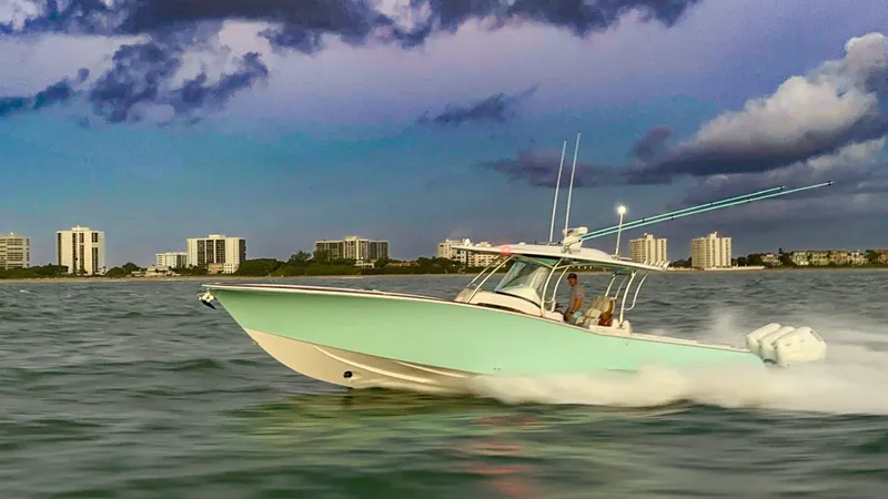 Slide: The Image of 2025 Mag Bay 38 CC boat cruising on calm water at sunset. - 2