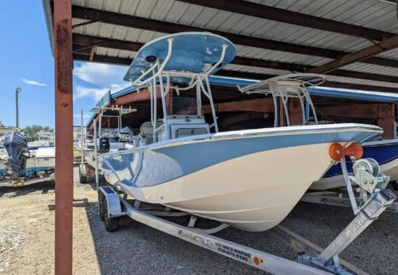 Slide: The Image of 2022 Carolina Skiff 24 Ultra Elite boat on a trailer under a metal canopy. - 1