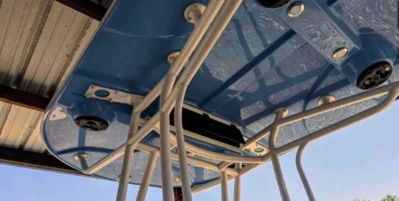 Slide: The Image of 2022 Carolina Skiff 24 Ultra Elite boat's blue T-top with rod holders and speakers. - 5