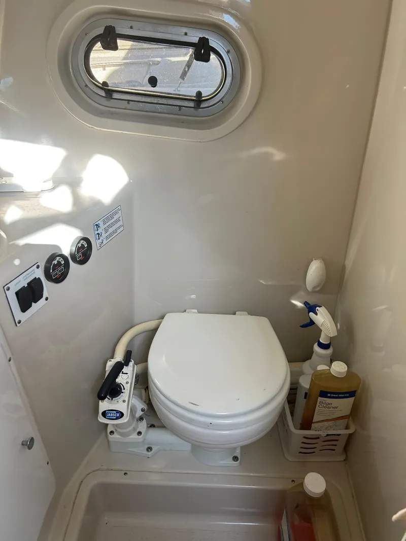 Slide: The Image of 2000 Four Winns 268 Vista boat bathroom with toilet and cleaning supplies. - 12